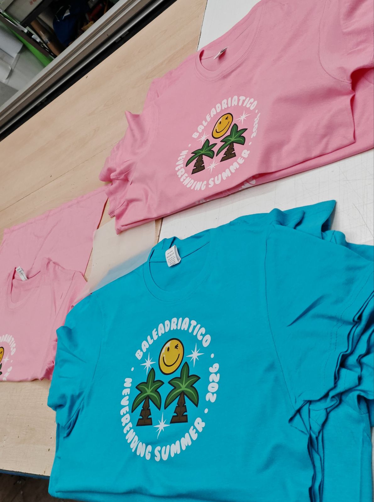 Magliette personalizzate rosa e azzurre con stampa DTF nel laboratorio Mediacreative a Lecce